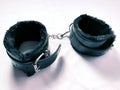 A pair of black furry leather sex toy handcuffs Royalty Free Stock Photo