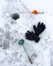 A pair of black gloves and a fishing pole are on a white surface Royalty Free Stock Photo