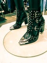 Pair of black metal studded buckle boots on a white background