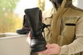 Pair black Safety Shoes, work boots made of leather with reinforced cape, high top in hands of young bearded man, builder in Royalty Free Stock Photo