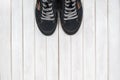 Pair of black sneakers on white wooden background. Royalty Free Stock Photo