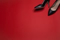 A pair of black spiked pumps shoes on red background Royalty Free Stock Photo