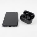 And a pair of black wireless earbuds in an open charging case are Royalty Free Stock Photo