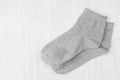 Pair blank grey medium socks flat lay on white wood board, side view - mock up for design, print, presentation, advertising.
