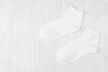 Pair blank white medium socks flat lay on white wood board, side view - mock up for design, print, presentation, advertising.