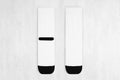 Pair blank white tall socks with black heel flat lay on white wood board, front view, backside - mock up for design, print.