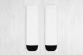 Pair blank white tall socks with black heel flat lay on white wood board, front view - mock up for design, print, presentation.