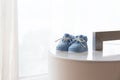 A pair of blue baby shoes against backlit window