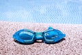 Pair of blue goggles by the pool Royalty Free Stock Photo