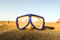 A pair of blue goggles is sitting on a sandy beach Royalty Free Stock Photo