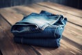 a pair of blue jeans folded on a wooden table with a wooden floor in the background and a wooden wall in the backround Royalty Free Stock Photo