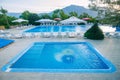 Pair of blue pools with umbrellas and chairs at a resort in the mountains of Central Asia Royalty Free Stock Photo