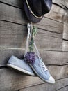 Pair of blue sneakers, blue hat and lavenders wooden fence in the garden