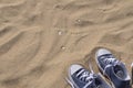 Blue unlaced sneakers on beach Royalty Free Stock Photo