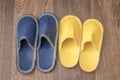 Pair of blue and yellow slippers are on the floor. Footwear for guests. There are male and female slippers in the bedroom. The Royalty Free Stock Photo