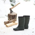 Pair of boots, firewood and axe in chump in the background