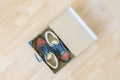 Pair of brand new shoes in shoe cartoon box on wooden floor f Royalty Free Stock Photo