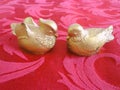 Pair of brass gilded ducks on pink fabric