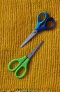 Pair of bright shiny silver steel fabric shears or designer scissors for cutting material lying on a grey textile