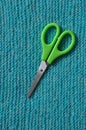 Pair of bright shiny silver steel fabric shears or designer scissors for cutting material lying on a grey textile