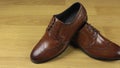 Pair of brown classic lace-up shoes standing on the floor. Slider shot.