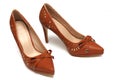 A pair of brown colored ladies high heels shoes with a bow ribbon at the front