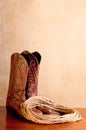 A pair of brown cowboy boots and rope