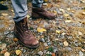 A pair of brown hiking boot in autumn forest. Soft focus on boot