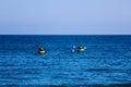 A pair of canoes in the Pacific. People kayak in the ocean