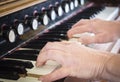 Pair of caucasian woman`s hands playing the organ.