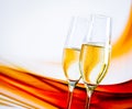 A pair of champagne flutes with golden bubbles on blur light background Royalty Free Stock Photo