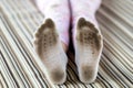 Pair of child feet in dirty stained white socks. Kid soiled socks while playing outdoors. Children clothes bleaching and