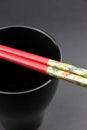 Pair of Chinese chop sticks on a black cup