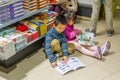 A pair of Chinese kids sitting on the floor and reading books at the Shenzhen Central Bookstore in Futian district, Shenzhen,