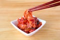 Pair of Chopsticks Grabbing a Piece of Mouthwatering Cabbage Kimchi, a Famous Traditional Korean Dish Royalty Free Stock Photo