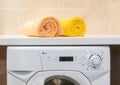 Pair clean rolled towels on washing machine.