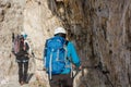 Pair of climbers walking on narrow ledge.