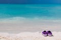 Pair of colored sandals on a white sand beach Royalty Free Stock Photo