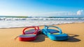 A pair of colorful flip flops resting on warm sandy beach Royalty Free Stock Photo