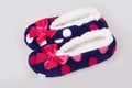A pair of colorful polka dot patterned warm cozy slippers with pink satin bows