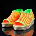 Pair of colorful rubber slippers on black background with reflection