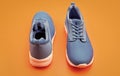 pair of comfortable blue sport shoes on orange background, fitness Royalty Free Stock Photo