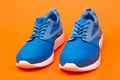 pair of comfortable blue sport shoes on orange background, jogging shoes Royalty Free Stock Photo