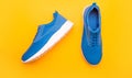 pair of comfortable blue sport shoes on yellow background, footgear