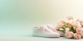 Pair of comfortable women sneakers on delicate green pastel background decorated with blooming beautiful flowers with