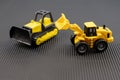 Pair of Construction Toys. Yellow Bulldozer and Loader on Black Background Royalty Free Stock Photo