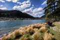 A pair of couple sit on the bench along the lakeside of Queenstown, New Zealand