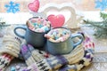 A pair of cups with a drink decorated with meringues and marshmallows, Christmas decor, hearts, knitted scarf