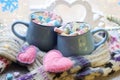 A pair of cups with a drink decorated with meringues and marshmallows, Christmas decor, hearts, knitted scarf