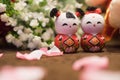 Pair of cute Chinese wooden dolls with red clothes smiling indoors